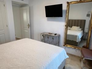 a bedroom with a bed and a mirror at Carvajal casa Tucan in Fuengirola