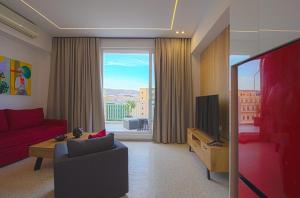 a living room with a red couch and a tv at Piraeus Harbor Hideaway in Piraeus