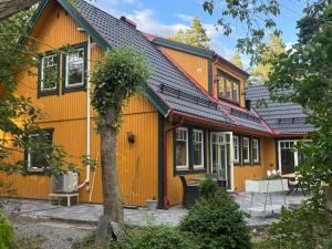 a yellow house with black roof at Pilvägen 7 Ekerö - Skå in Skå