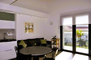 a living room with a couch and a table at Giardino di Lei, appartamento Verde in Montegrotto Terme +12 photos