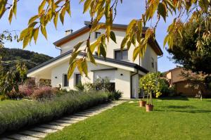 a white house with a green yard at Giardino di Lei, appartamento Verde in Montegrotto Terme