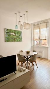 a living room with a table and chairs and a tv at Studio8 in Bollate