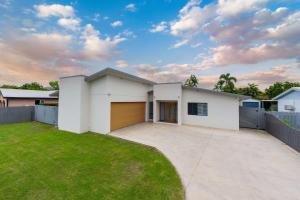 a white house with a garage at Magic on MacArthur in Rosslea +14 photos