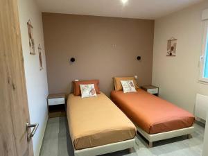 una habitación con dos camas en una habitación en Gîte Le Gros Chêne, en Taintrux