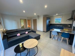 una sala de estar con un sofá y una mesa en Gîte Le Gros Chêne, en Taintrux 3 fotos más