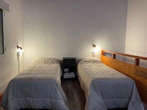 Un dormitorio con dos camas y dos luces encendidas. en Cabaña Familia de Campo 3, en El Chaltén