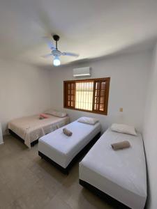 a bedroom with two beds and a ceiling at Beach Milionario in Guarujá
