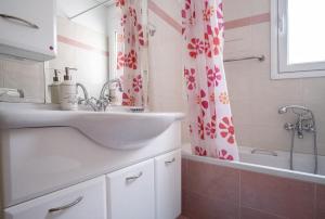 Un baño con lavabo y cortina de ducha. en Family home in Lagonisi, en Lagonisi 25 fotos más
