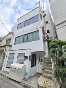 a white building with a refrigerator in front of it at 2025年10月リニューアル! SLEEPLAB駒込-Komagome- in Tokyo