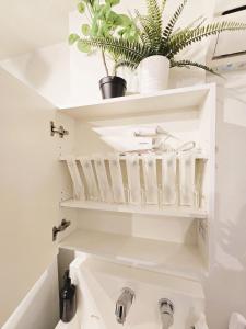 a bathroom with white shelves and a sink at 2025年10月リニューアル! SLEEPLAB駒込-Komagome- in Tokyo