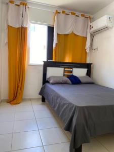 a bedroom with a bed with orange curtains and a window at Residencial Mais Viver São Francisco in Petrolina +12 photos