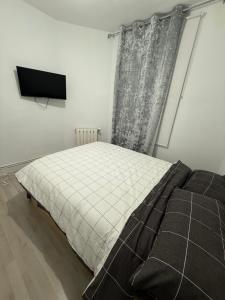 Un dormitorio con una cama y un televisor. en Petithouse Madrid Camino Viejo, en Madrid