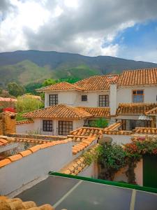 a view of a house with mountains in the background at H-OSTELLO LA MERIDIANA in Villa de Leyva