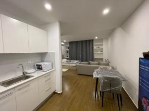 a kitchen and living room with a table and a couch at Mix Center in Belas