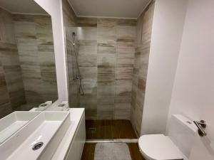 a bathroom with a sink and a toilet and a shower at Mix Center in Belas +2 photos
