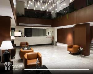 a lobby with couches and chairs in a building at Youssif Hotel in Dakākīn Ḩamīd