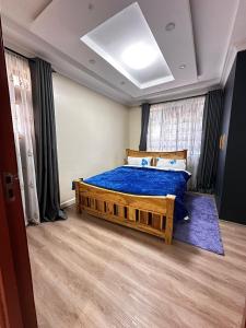 a bedroom with a bed with a blue comforter at Nanyuki House in Nanyuki