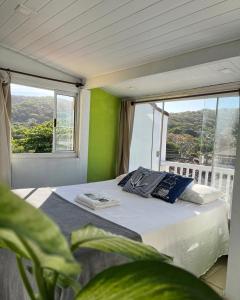 a bed in a room with a large window at Luah Buziana in Búzios