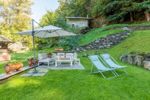 a patio with a table and chairs and an umbrella at Chalet 181 in Arvier