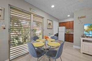 a dining room with a table and chairs and a kitchen at Peaceful condo with pool and steps to beach in Marco Island