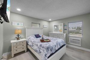 a bedroom with a white bed and two windows at Peaceful condo with pool and steps to beach in Marco Island +35 photos