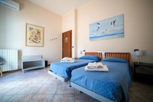 a bedroom with two beds with towels on them at Residence Hotel Azzurro in LʼAquila