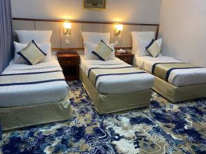 a hotel room with two beds and a carpet at فندق الأزهر النزهة - Al Azhar Nuzhah Hotel in Mecca +21 photos