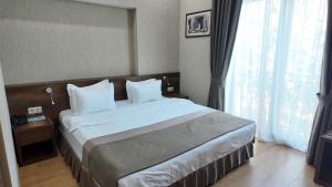a hotel room with a large bed and a window at Metekhi Line By OldTown in Tbilisi City +20 photos