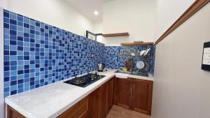 a kitchen with blue tiles on the walls and a counter at Như House Apartment - Phú Quốc in Phú Quốc