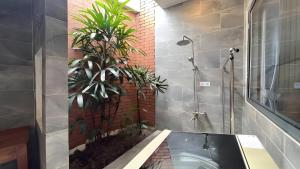 a bathroom with a shower and a sink with a plant at Như House Apartment - Phú Quốc in Phú Quốc +77 photos