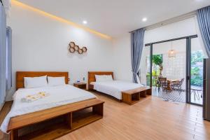 a bedroom with two beds and a balcony at Như House Apartment - Phú Quốc in Phú Quốc