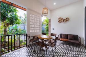 a dining room with a table and chairs and a couch at Như House Apartment - Phú Quốc in Phú Quốc