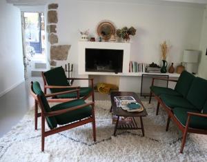 un salon avec des chaises vertes et une table dans l'établissement Maison de charme, jardin clos sud, terrasse, 2 minutes plages, au cœur du village de Piriac, 4 chambres 2 SDB., à Piriac-sur-Mer