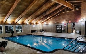 a large swimming pool in a building with a ceiling at AmericInn by Wyndham McAlester in McAlester