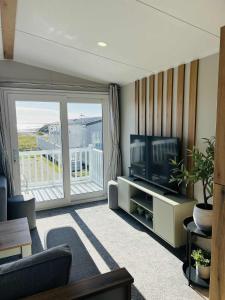 a living room with a television and a balcony at Haven Berwick in Berwick-Upon-Tweed +9 photos