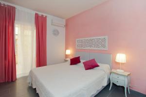 um quarto com paredes cor-de-rosa e uma cama com cortinas vermelhas em Canto dei Mille em Florença