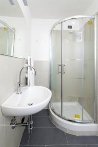 uma casa de banho com um lavatório e uma cabina de duche em vidro. em Canto dei Mille em Florença
