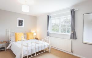 a bedroom with a white bed and a window at Spacious 3 Bed Cottage Near Beaches in Georgeham