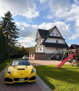 un'auto gialla parcheggiata di fronte a una casa di Pokoje W Górach Savanna a Biały Dunajec