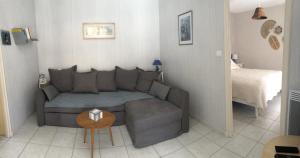 a small living room with a couch and a bed at Chez Christine et Jean-Louis in Fouras