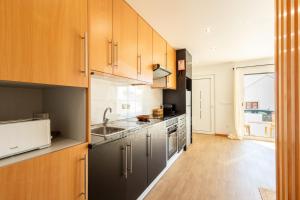 a kitchen with stainless steel appliances and wooden cabinets at Valentin House by ACasaDasCasas in Santo Isidoro