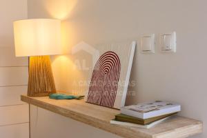 a table with a lamp and books on it at Valentin House by ACasaDasCasas in Santo Isidoro