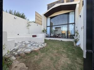 a house with a large window on the side of it at غصن الهدا in Al Hada