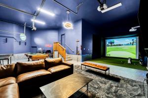 a living room with a couch and a large screen television at Epic Hillside Retreat Htd Pool HotTub Golf 4400sf in Boise
