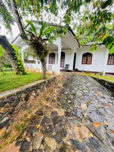 una casa con un árbol y una entrada de piedra en Coastal breezy bangalow, en Weligama