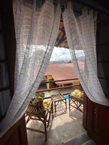 a view of a balcony with chairs and a window at Pousada Acquarela Paraty - SOB NOVA DIREÇÃO!!! in Paraty