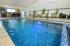 a large swimming pool in a large building at וילה סאן טורינו - Vila San Torino in Elqosh