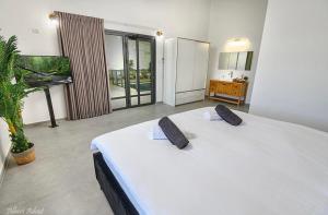 a large white bed in a room with a plant at וילה סאן טורינו - Vila San Torino in Elqosh