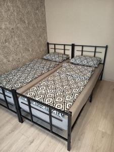 ein Bett mit schwarzem Rahmen und Kissen darauf in der Unterkunft Vieno kambario butas Šiauliuose in Šiauliai + 6 Fotos