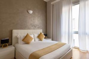 a bedroom with a large white bed and a window at Wonderful apartment a few steps from the Duomo - Milan in Costermano sul Garda